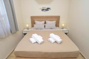 Un dormitorio con una cama con toallas blancas. en Bradasevic Apart Resort Tivat en Tivat