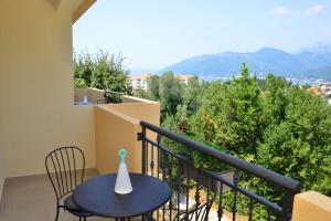 balcón con mesa azul, sillas y montañas en Bradasevic Apart Resort Tivat en Tivat