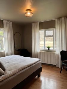 ein Schlafzimmer mit einem Bett, einem Stuhl und einem Fenster in der Unterkunft Jökla Guesthouse in Skjöldólfsstaðir