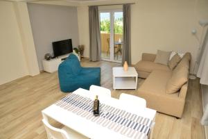 ein Wohnzimmer mit einem Sofa und einem Tisch in der Unterkunft Bradasevic Apart Resort Tivat in Tivat