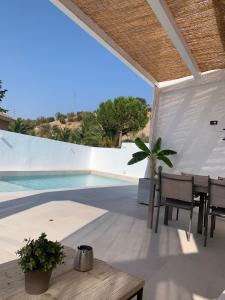 a patio with a table and chairs next to a swimming pool at Casa Genilla in Priego de Córdoba