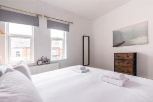 - une chambre blanche avec un lit blanc et des fenêtres dans l'établissement Lumley House - Delightful 2BR Terraced House near Birmingham, à Walsall