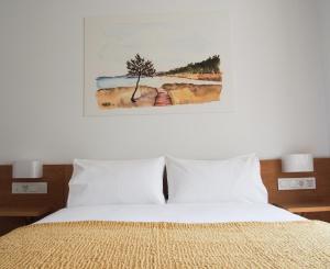 1 dormitorio con 1 cama con una pintura en la pared en HOTEL BOUTIQUE VILAVELLA en O Grove