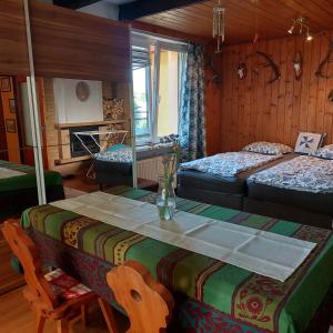 a room with two beds and a table and chairs at U domečku s keramikou in Karlovy Vary