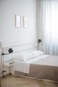 ein weißes Schlafzimmer mit einem Bett und einem Fenster in der Unterkunft Dall Arca Smart Flat - Central Station Checkpoint in Bari