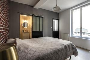 エペルネーにあるAppartement Hyper Centre, Avenue de Champagne à 200 mètresのベッドとレンガの壁がある寝室