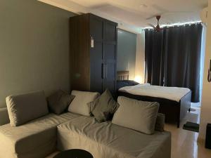 ein Wohnzimmer mit einem Sofa und einem Bett in der Unterkunft Elegantly designed Studio Apt in Thane