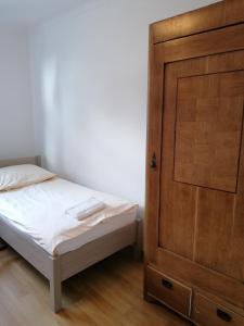 sypialnia z łóżkiem i drewnianymi drzwiami w obiekcie Zielony Zakątek w mieście Krynki