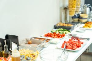 un buffet con varias bandejas de comida en un mostrador en New Amaryllis Hotel en Atenas