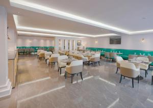 une salle à manger avec des tables et des chaises blanches dans l'établissement Stay Easy Plus Hotel, à Addis-Abeba