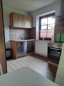 a kitchen with wooden cabinets and a sink and a stove at Ferienwohnungen NordseeStern in Burhave +7 photos