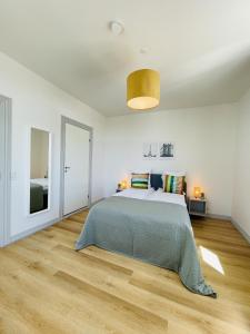 um quarto com uma cama e piso em madeira em aday - Green Light Apartment Suite in the center of Hjorring em Hjørring