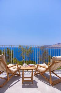 three chairs and a table on a balcony with the ocean at Born in Blue in Kaş