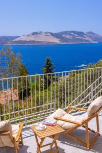 a chair and a table on a balcony with the ocean at Born in Blue in Kaş