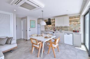 a kitchen and dining room with a white table and chairs at Born in Blue in Kaş