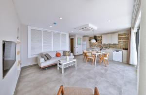 a living room and kitchen with a couch and a table at Born in Blue in Kaş
