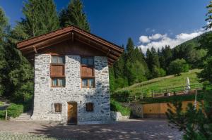 un bâtiment en pierre avec un toit en bois dans l'établissement Maso Noce, à Mezzana