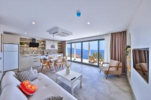 a living room with a couch and a table and a kitchen at Born in Blue in Kaş