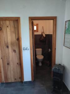 a bathroom with a toilet and a wooden door at Camping Kromidovo in Kromidovo