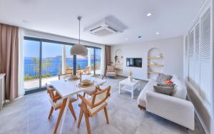 a living room with a table and chairs and a large window at Born in Blue in Kaş