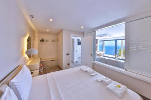 a bedroom with a large window with a view of the ocean at Born in Blue in Kaş