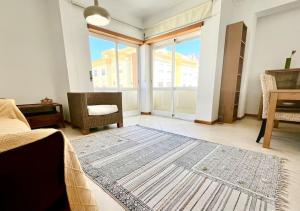 ein Wohnzimmer mit einem großen Teppich auf dem Boden in der Unterkunft Porto d’Areia Beach House in Peniche