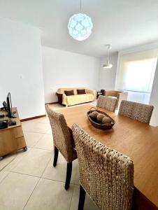 uma sala de estar com uma mesa de madeira e cadeiras em Porto d’Areia Beach House em Peniche