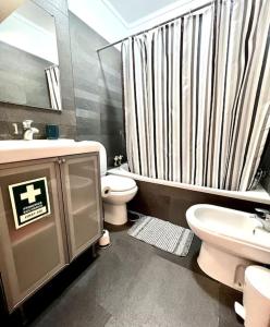 uma casa de banho com um lavatório, um WC e um chuveiro em Porto d’Areia Beach House em Peniche