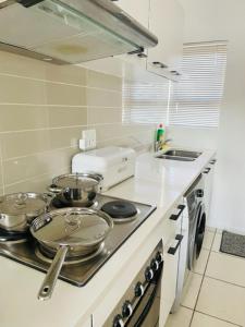 a kitchen with three pots and pans on a stove at Hidden Gem in Midrand