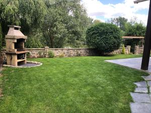 a garden with a stone fence and a grass yard at Chalet La Bohème in Prouilly +3 photos