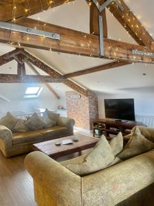 a living room with two couches and a table at Beach House 3 Bed Penthouse Apartment in Southport