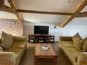 a living room with two couches and a tv at Beach House 3 Bed Penthouse Apartment in Southport