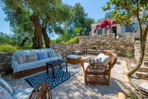 um pátio com cadeiras, um sofá e uma mesa em Malethonas Cottage by All About Paxos em Gaios