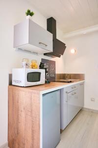 a kitchen with a microwave on top of a counter at L'appartement in Pontarlier