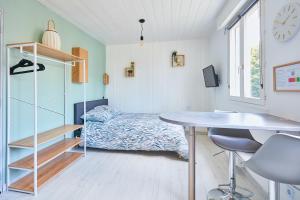 um quarto com uma cama, uma secretária e uma mesa em L'appartement em Pontarlier