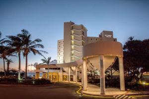 un grand bâtiment avec un rond-point en face dans l'établissement Beverly Hills, à Durban