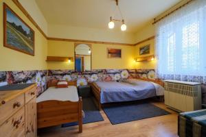 a bedroom with two beds and a large window at 4 Évszak Apartman in Gyula