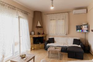 a living room with a couch and a fireplace at Villa de N.A.P.E in Hanioti