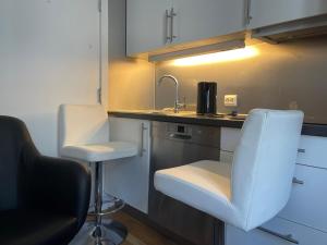 a kitchen with a sink and a counter with two stools at Oslo apartment center in Oslo