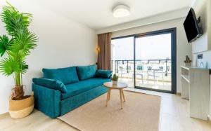 a living room with a blue couch and a table at Bakour Lanzarote Splash in Puerto del Carmen