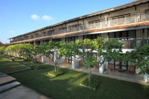an apartment building with trees in front of it at Avani Bentota Resort in Bentota