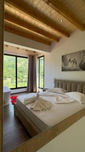 een slaapkamer met een groot bed en een groot raam bij Hotel Nemercka in Përmet