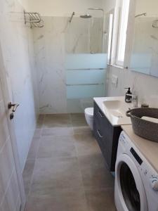 a bathroom with a washing machine and a sink at M&D appartments in Komiža +24 photos