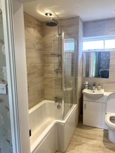 a bathroom with a tub and a sink and a toilet at Creamore Grove Wem Shrewsbury in Wem +34 photos
