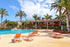 a resort with a pool and chairs and palm trees at Relax in Paraiso by Olax Rentals in Playa Paraiso