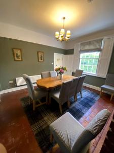 uma sala de jantar com uma mesa de madeira e cadeiras em Creamore Grove Wem Shrewsbury em Wem