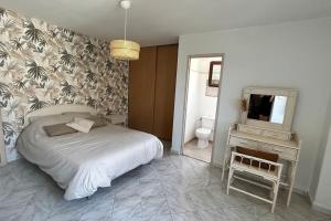 a bedroom with a bed and a vanity and a mirror at Casa Ghjuvanna 2 chambres in Prunelli-di-Fiumorbo