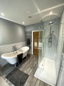 uma casa de banho com uma banheira, um lavatório e um chuveiro em Creamore Grove Wem Shrewsbury em Wem