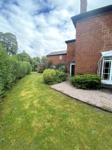 a brick building with a grass yard in front of it at Creamore Grove Wem Shrewsbury in Wem