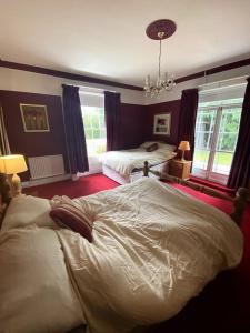 a bedroom with two beds and a chandelier at Creamore Grove Wem Shrewsbury in Wem
